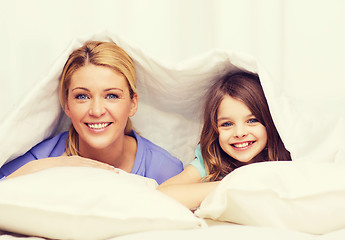 Image showing mother and little girl under blanket at home