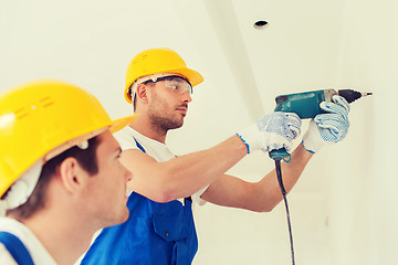 Image showing group of builders with drill indoors