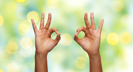 Image showing two african hands showing ok sign over blue sky