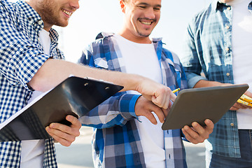 Image showing group of smiling builders with tablet pc outdoors