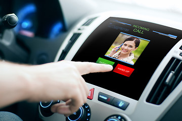 Image showing male hand receiving video call on car panel screen