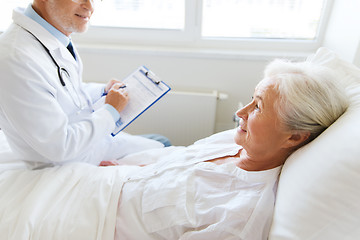 Image showing senior woman and doctor with clipboard at hospital