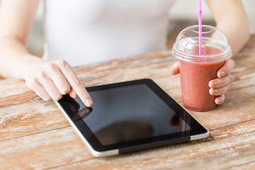 Image showing close up of woman with tablet pc and smoothie