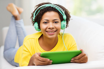 Image showing happy african woman with tablet pc and headphones