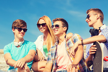 Image showing group of smiling friends sitting on city street