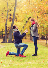 Image showing smiling couple with engagement ring in gift box