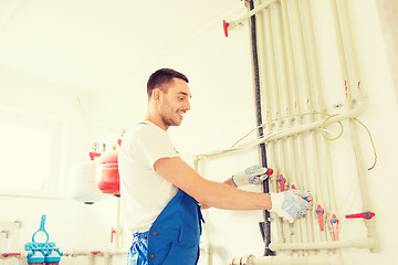 Image showing smiling builder or plumber working indoors