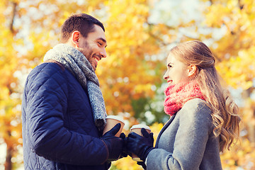 Image showing smiling couple with coffee cups in autumn park