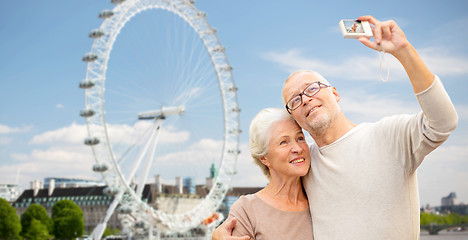 Image showing senior couple selfie with camera over london