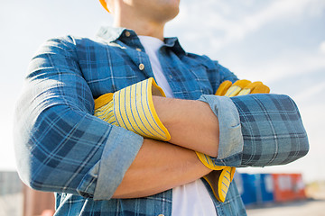 Image showing close up of builder crossed hands in gloves