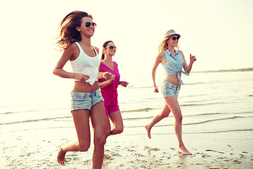 Image showing group of smiling women running on beach