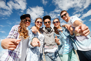 Image showing smiling teenagers in sunglasses hanging outside