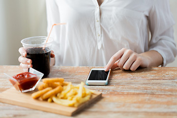 Image showing close up of woman with smart phone and fast food
