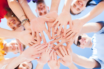 Image showing many hands over blue sky background