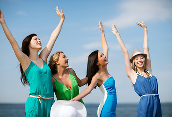 Image showing girls looking at the sea with hands up