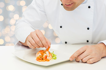 Image showing close up of happy male chef cook decorating dish