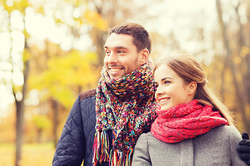 Image showing smiling couple hugging on bridge in autumn park