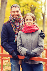 Image showing smiling couple hugging on bridge in autumn park