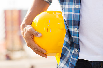 Image showing close up of builder hand holding hardhat outdoors