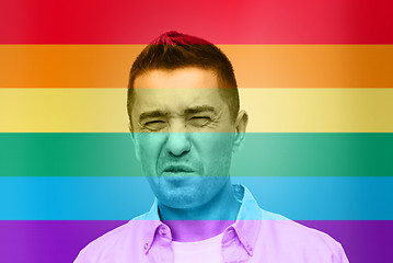 Image showing gay man wrying over rainbow flag background