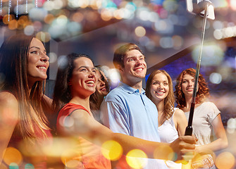 Image showing friends with smartphone taking selfie in nightclub