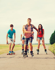 Image showing group of smiling teenagers with roller-skates