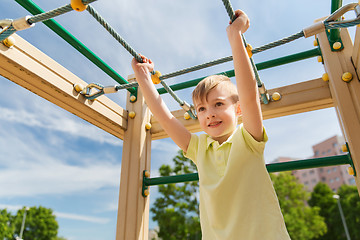 Image showing happy little boy climbing on children playground