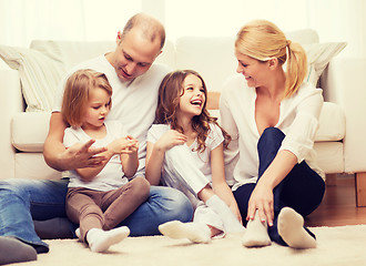 Image showing parents and two girls sitting on floor at home