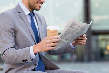 Image showing close up of smiling businessman reading newspaper