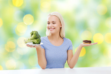 Image showing smiling woman with broccoli and donut