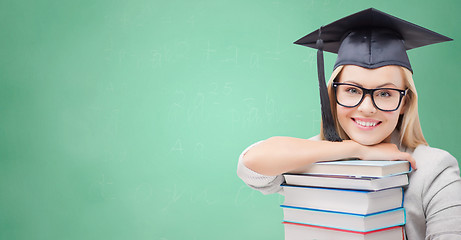 Image showing student in trencher cap with books over green