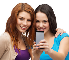 Image showing two smiling teenagers with smartphone