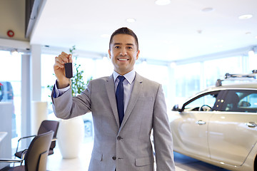 Image showing happy man showing key at auto show or car salon