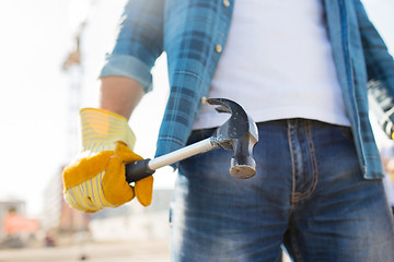 Image showing close up of builder hand in glove holding hammer