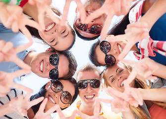 Image showing smiling friends in circle on summer beach