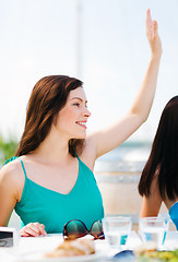 Image showing girl waving hand in cafe on the beach