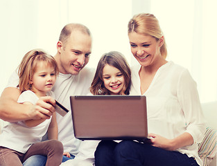 Image showing parents and two girls with laptop and credit card