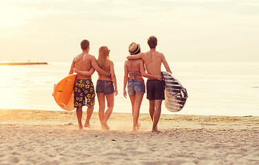 Image showing smiling friends in sunglasses with surfs on beach