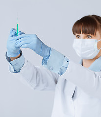 Image showing female doctor holding syringe with injection