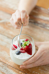 Image showing close up of woman hands with yogurt and berries