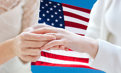 Image showing close up of lesbian couple hands with wedding ring