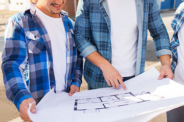 Image showing close up of smiling builders with blueprint