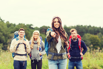 Image showing smiling hikers with backpacks pointing finger