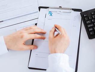 Image showing male doctor writing prescription paper