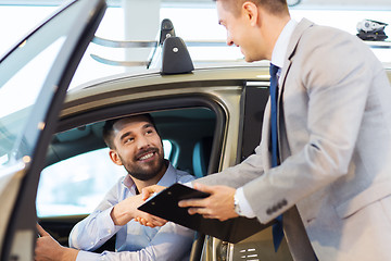 Image showing happy man with car dealer in auto show or salon