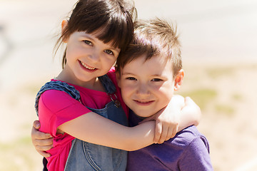 Image showing two happy kids hugging outdoors