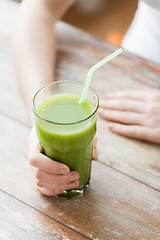 Image showing close up of woman hands with green juice