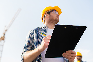 Image showing builder in hardhat with clipboard outdoors