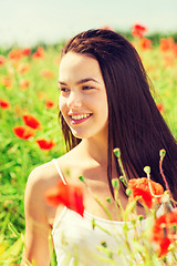 Image showing smiling young woman on poppy field