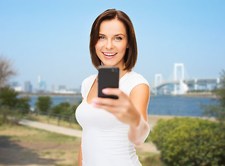 Image showing woman taking selfie with smartphone over tokyo